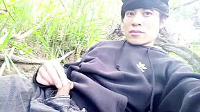 The cute gay twink jerks his cock outdoors